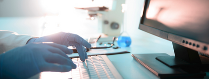 Imagem de duas mãos digitando em um teclado no laboratório representando o sistema para laboratório